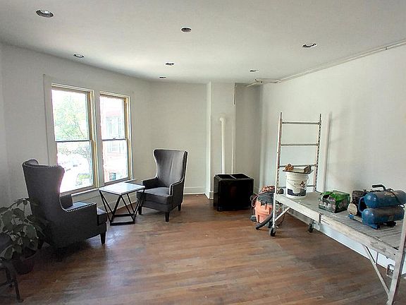 Large living room with 10 foot ceilings and 3 full height windows.