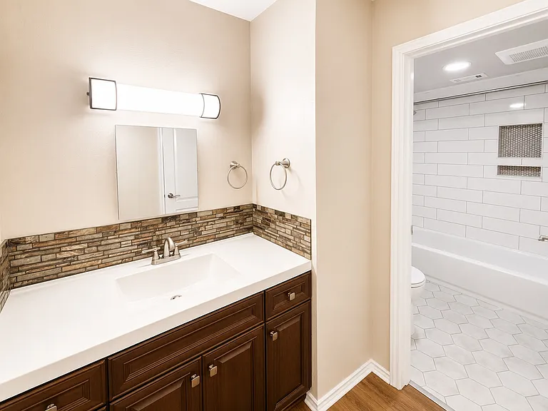 Vanity area with view to the separate bathtub room