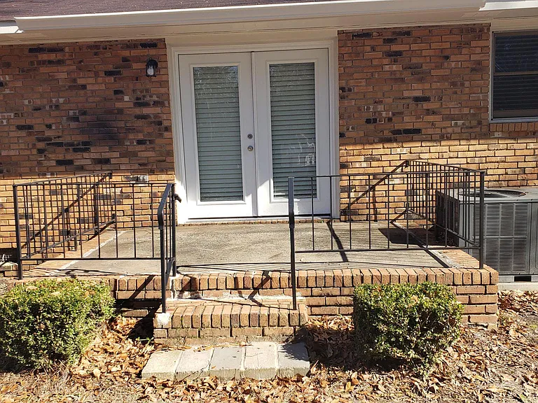 Closeup view of rear patio doors and patio area. Great for grilling and relaxing; Winter time photo; green grass during Summer. Freshly painted.