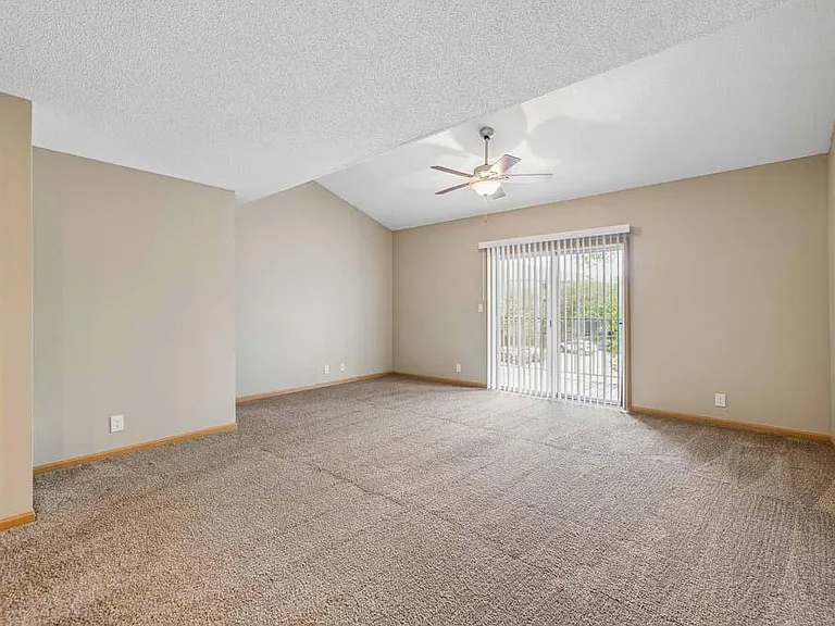 The expansive living area features soaring ceilings, abundant natural light, and seamless access to your private balcony for easy indoor-outdoor living.