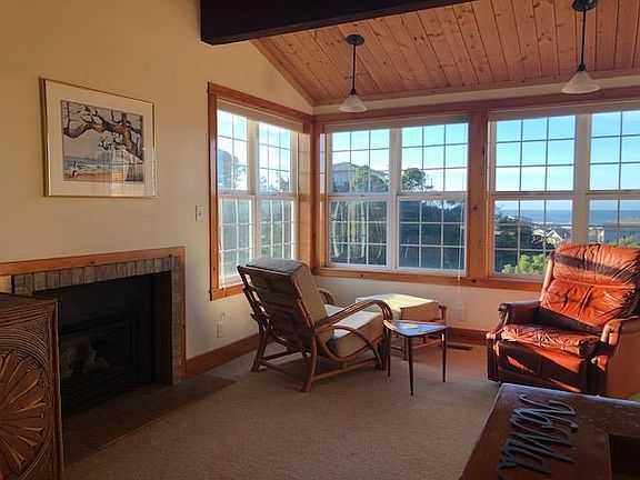 Living area with gas fireplace and view of ocean and Yaquina Head lighthouse