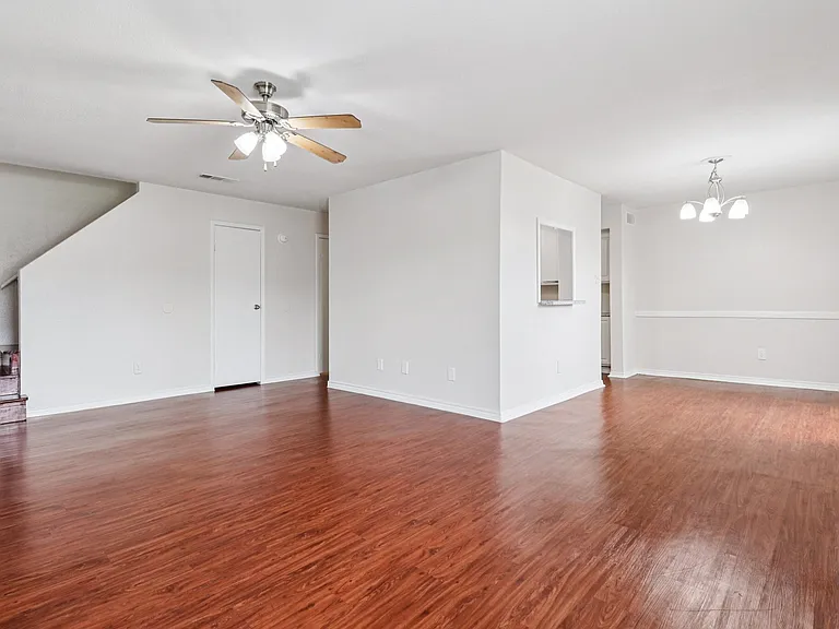 Bright and spacious living area with elegant wood-style floors, modern ceiling fan, and inviting natural light, ideal for comfortable living. Bright and spacious living area with elegant wood-style floors, modern ceiling fan, and inviting natural light, i