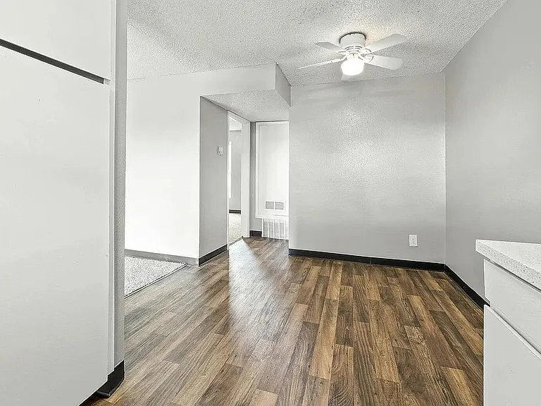 Bright and modern apartment featuring sleek wooden flooring and light gray walls, ideal for a contemporary living space.