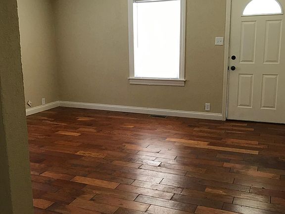 Living room with hardwood flooring which is same in all three bedrooms.
