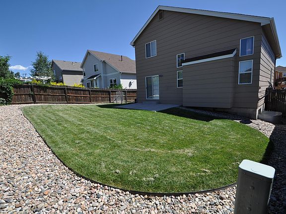 Fenced-in back yard with sprinkler system and large patio... perfect for a barbecue!