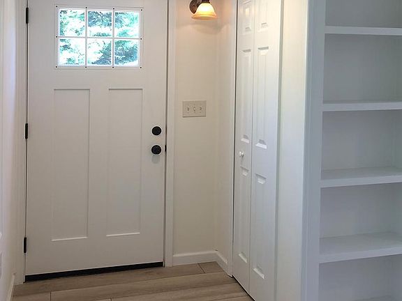 front door, coat closet and built in book case