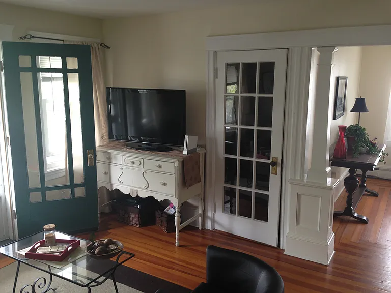 Living room view. Balcony door is on the left. open entryway on the right is bonus room. Door is closet door.