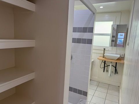 Bathroom with open-shelving storage .