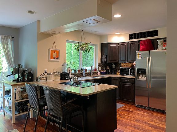 Kitchen opens to second living area with glass sliding door to back deck/backyard.