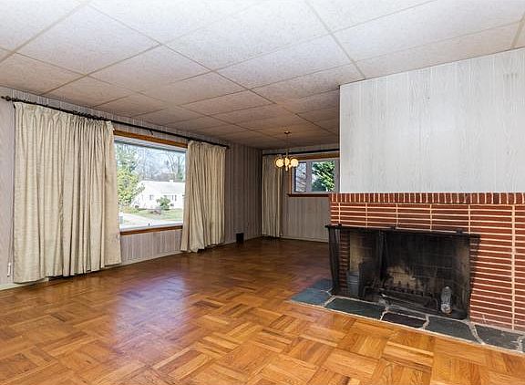 Living room has a wood-burning brick fireplace