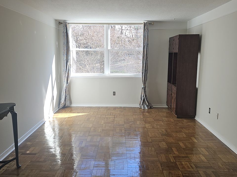 Living/Dining Room with pass through window from kitchen. View of back garden and trees.