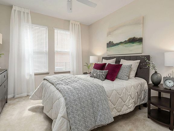 Spacious bedroom with plush carpeting, large windows, and modern finishescomfortable apartment living in Charlotte.