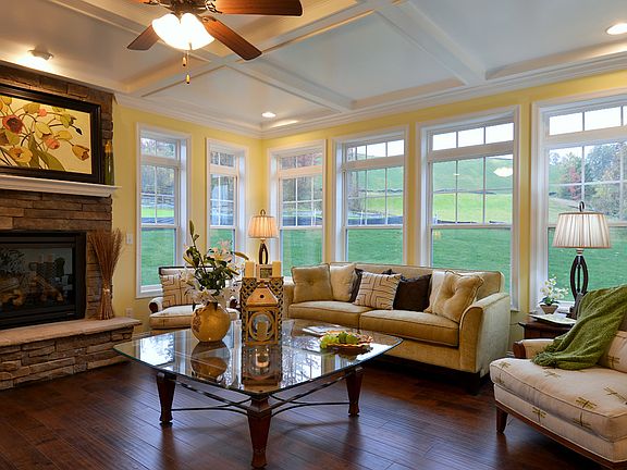 Family room with gas fireplace with stone surround and wall of windows