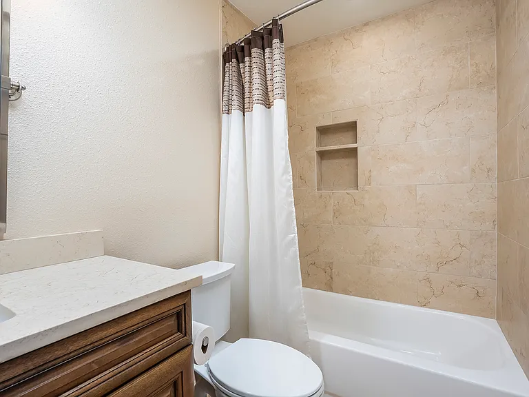 Fully remodeled guest bath with travertine tile.