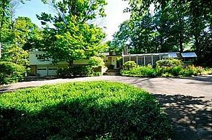 Exterior Front. Entry surrounded by gardens