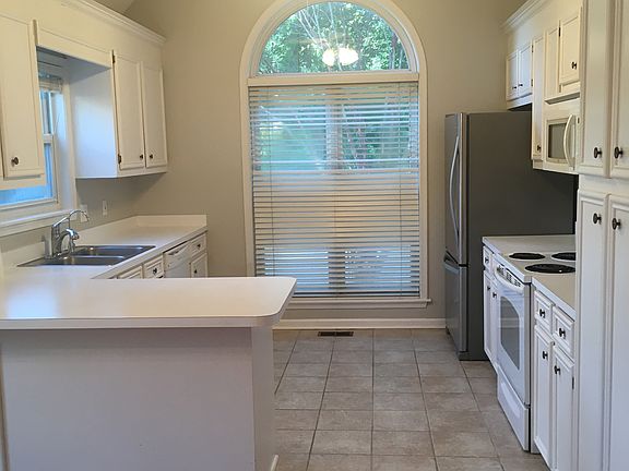 Spacious kitchen with vaulted ceilings and modern appliances. Includes dishwasher, oven/range, microwave, refrigerator