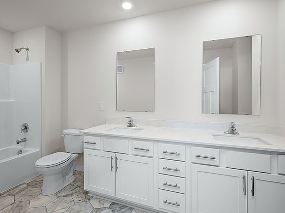The master bathroom has a dual sink vanity and a tub shower combo