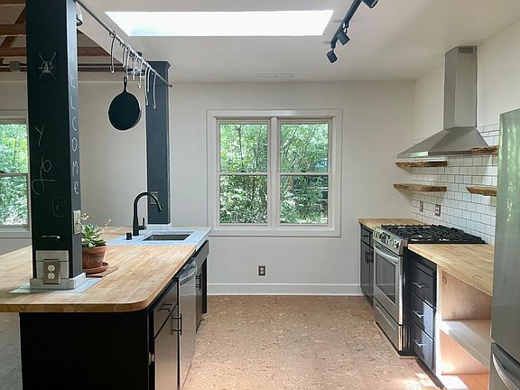 Modern chef's kitchen with butcher block counter tops and lots of natural lighting.