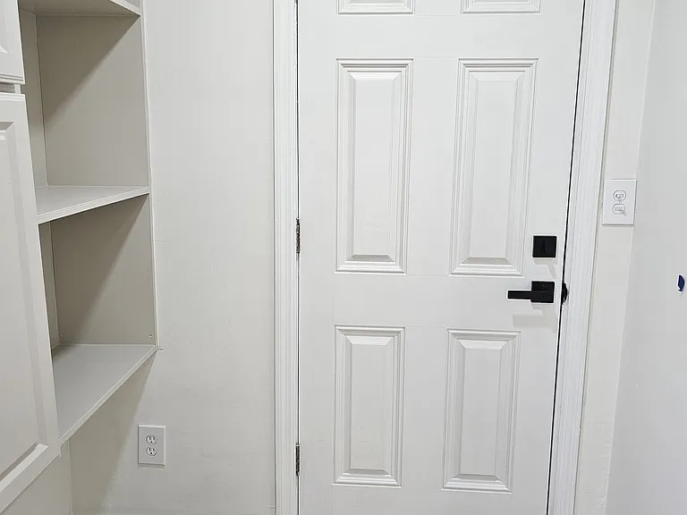 Exit to the spacious backyard through the kitchen. Additional cabinet on the left. Plenty of storage space all around.
