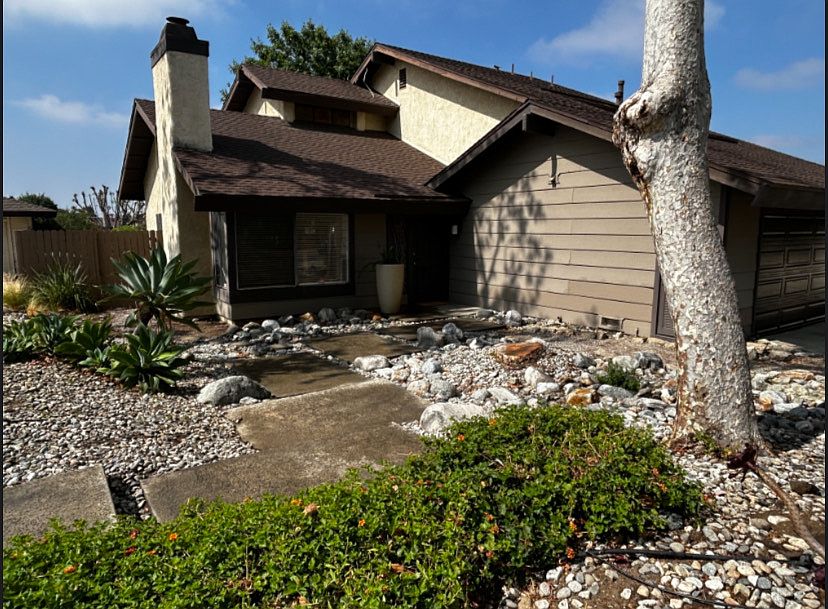 House front with Native landscaping and river rock.