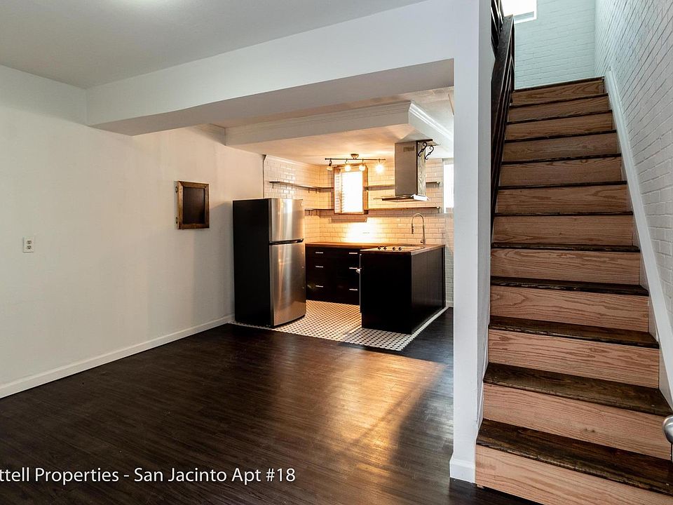 A view of the living area, kitchen, and stair case from the front door