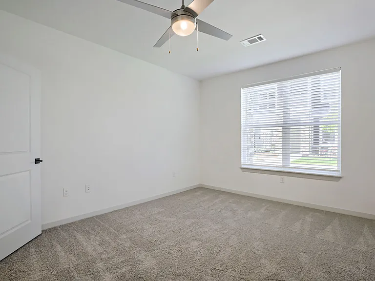 Spacious bedrooms with plush carpet, ceiling fans, and oversized windows fill your space with natural light _ Garrett Harvest Junction West, Longmont, CO.