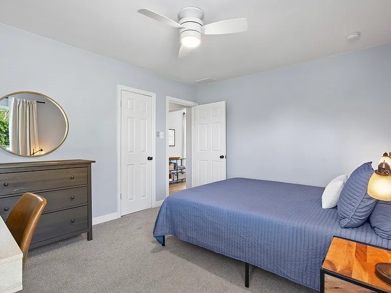 Bedroom with queen bed and workspace.