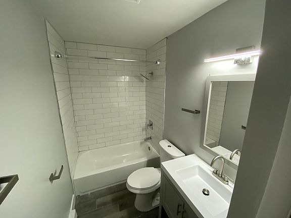 Bathroom with tiled shower and cool tiled floor