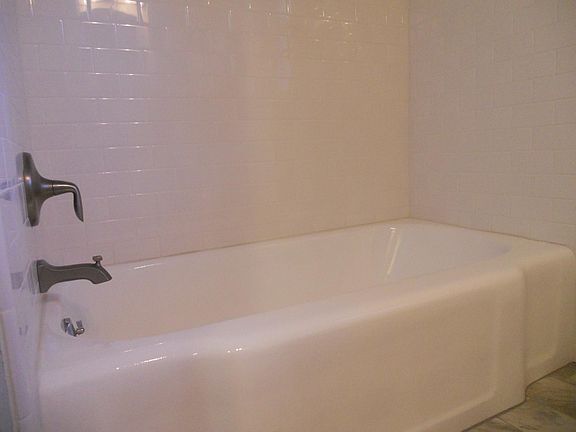 Refinished iron tub with antique bronze trim.