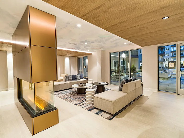 Gather in the elegant lounge at Modera Liberty Row, featuring a sleek fireplace and inviting seating just minutes from Uptown Charlotte.