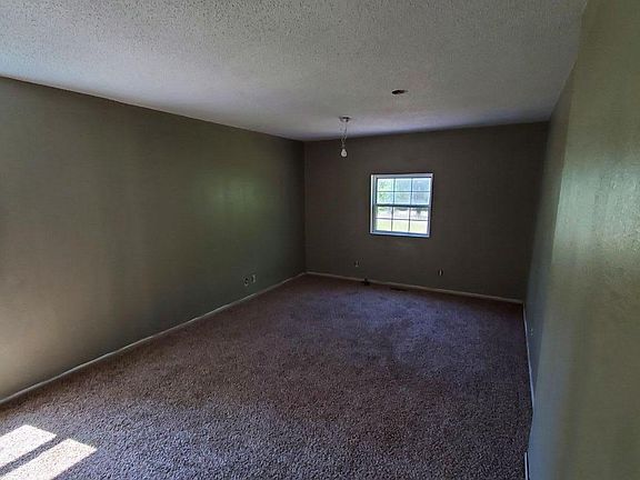 LARGE Front bedroom. ~12ftx20ft Picture taken from doorway. Ceiling fan with lights to be installed. Wall color is a gray color. Traditional double sliding door closet is on the left-hand side when you walk into the room, just outside of this picture.