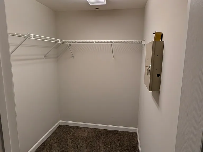 Walk-in closet off of primary bedroom with built-in wire shelving.
