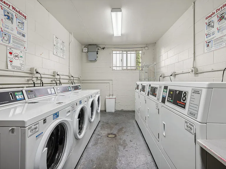 Laundry room with washing machines neatly arranged on a wooden floor