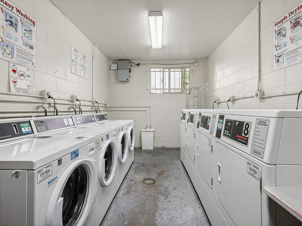 Laundry room with washing machines neatly arranged on a wooden floor