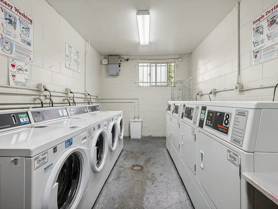 Laundry room with washing machines neatly arranged on a wooden floor