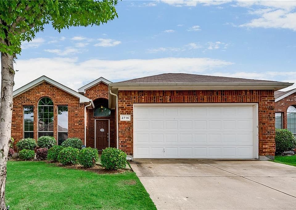 Front of the house with garage and drive wide enough to park two cars outside.