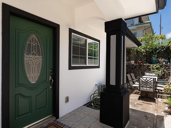 Front door with the only patio at property reserved for this unit along with table and chairs for enjoying the space