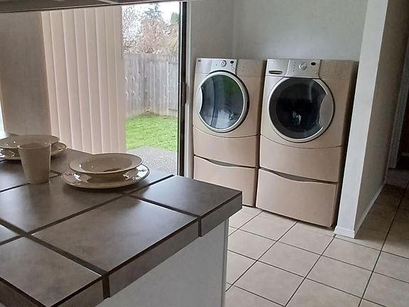 Front loading washer and dryer with pedestal storage