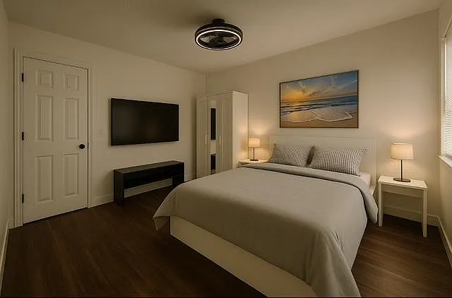 Queen bedroom with wall-mounted TV, bedside tables with lamps, and a wardrobe for convenient storage.
