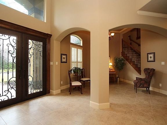 Custom double iron doors with decorative iron works greet family and friends to this warm and inviting home!