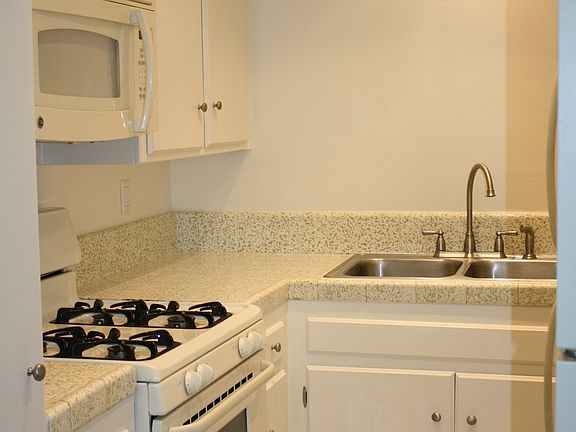 Light and bright kitchen with double sink, microwave, oven/range and fridge.