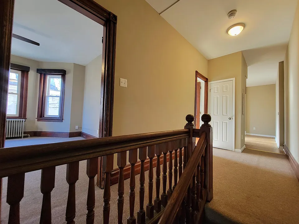 view from top of stairs (1st to 2nd floor); kitchen on right; bathroom middle; room #1 on left