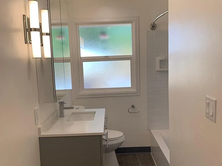 Newly renovated bathroom featuring brand new flooring, vanity and sink