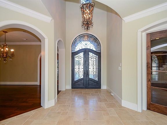 Enter into this beautiful property with a high end chandelier that greets you as you walk through the custom iron doors! Is this a two story entrance which gives this home a very grand feel!