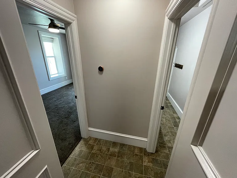 Hallway off of kitchen leads to master bedroom with ensuite bath to the left and powder room/guest bath on the right