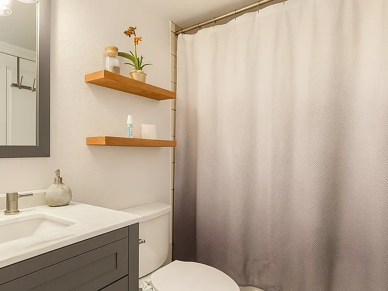 Stylish bathroom with modern fixtures, earthy wood accents, and a clean, calming atmosphere.