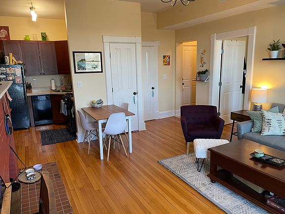 Living room w/ dining area in front of kitchen