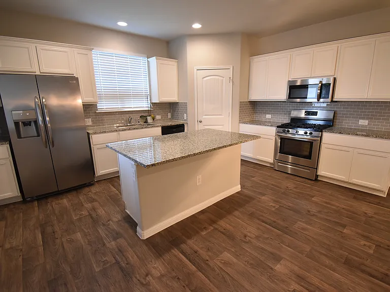 Kitchen featuring a large island with stainless steel appliances and granite counters