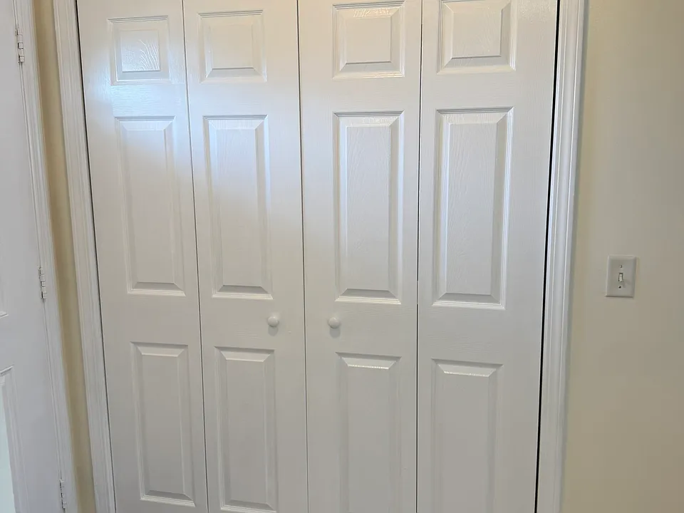 Laundry closet doors to access washer and dryer. Area located next to main door entrance.