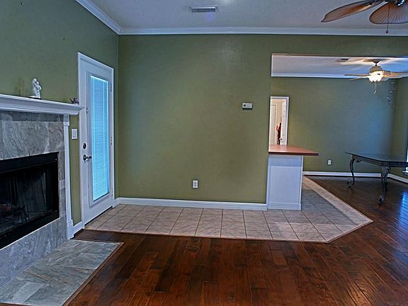 The living room has a modern wood burning fireplace with marble tile and decorative mantle.